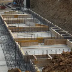 Budowa fundamentów: zbrojenie i szalunki betonowe na placu budowy.