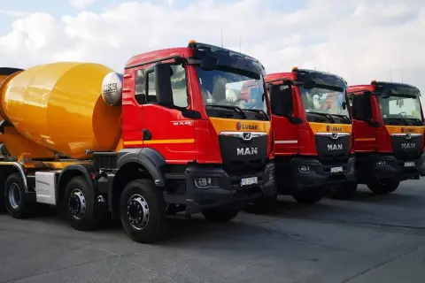 Rzędy czerwonych gruszek betonu MAN LUBAR. Zastanawiasz się, ile kosztuje gruszka betonu? Te potężne maszyny budowlane są gotowe do pracy.